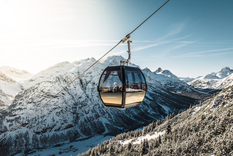 Gondel mit Moet Chandon Champagner Branding. Im Hintergrund eine sonnige Berglandschaft.