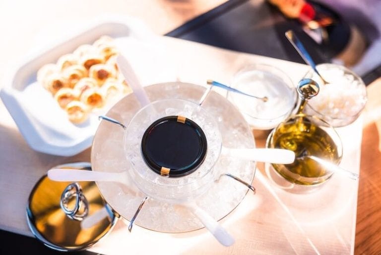 Edle Appetithäppchen mit Kaviar und Olivenöl auf einem Tisch in der Moet Champagner Gondel.