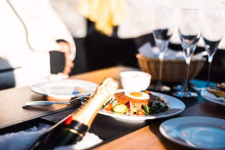 Gedeckter Tisch mit Champagnerflasche, frischem beef Tartare und Sektgläsern, serviert in der Moet Champagner Gondel.