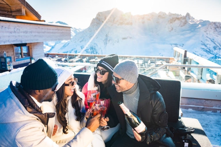 Gemeinsames Genießen und Anstoßen mit Champagner auf der Sonnenterrasse in den Alpen.
